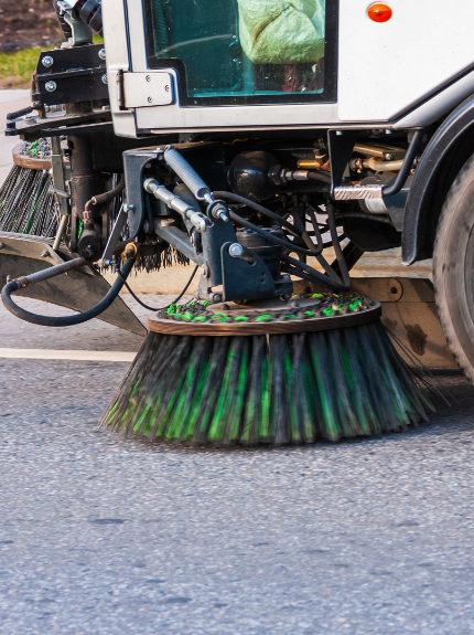 image of a street sweeper driving down a road